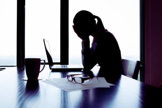 Gestresste Frau mit Hormonstörungen im Büro